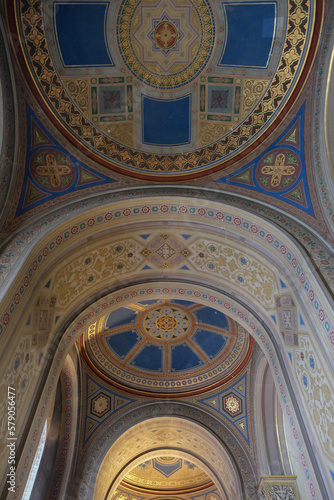 Monumental church building in Gothic in neo-romanesque arch style with large ceiling and altar murals and fresco, opulent detailed columns and marble structures