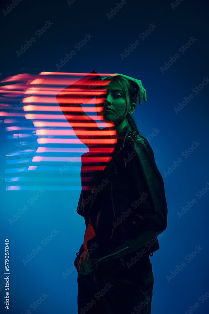 Half-length portrait of young stylish woman posing over dark blue background with neon mixed light lines. Concept of contemporary art, fashion, cyberpunk, futurism - obrazy, fototapety, plakaty 