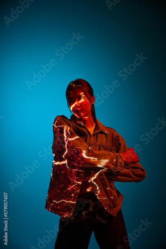 Energy. Futuristic style portrait of young woman with digital neon filter lights on clothes over dark blue background.