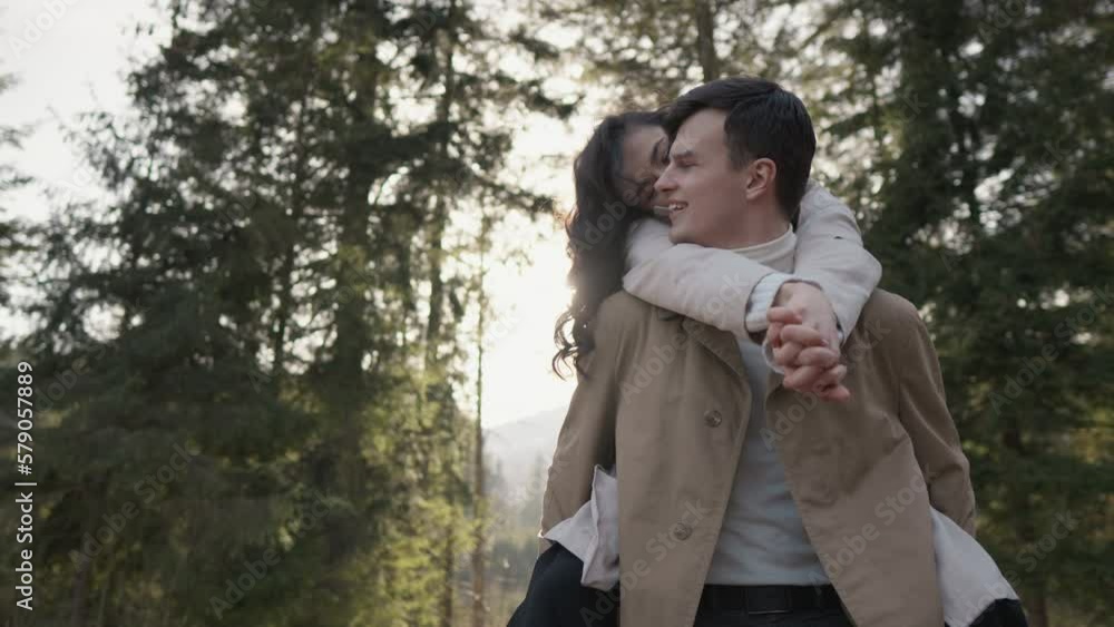 Young couple lovers in forest on nature. Guy walks with girlfriend in park. Joyful and romantic man and woman are relaxing in open area and fresh air in summer, autumn or spring. Love relationships Young couple lovers in forest on nature. Guy walks with girlfriend in park. Joyful and romantic man and woman are relaxing in open area and fresh air in summer, autumn or spring. Love relationships