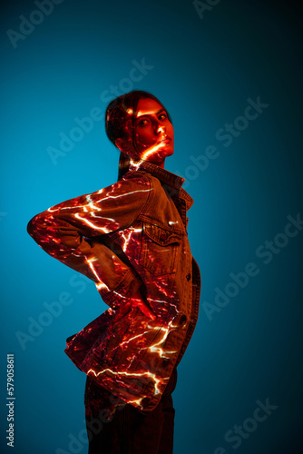 Energy. Futuristic style portrait of young woman with digital neon filter lights on clothes over dark blue background.