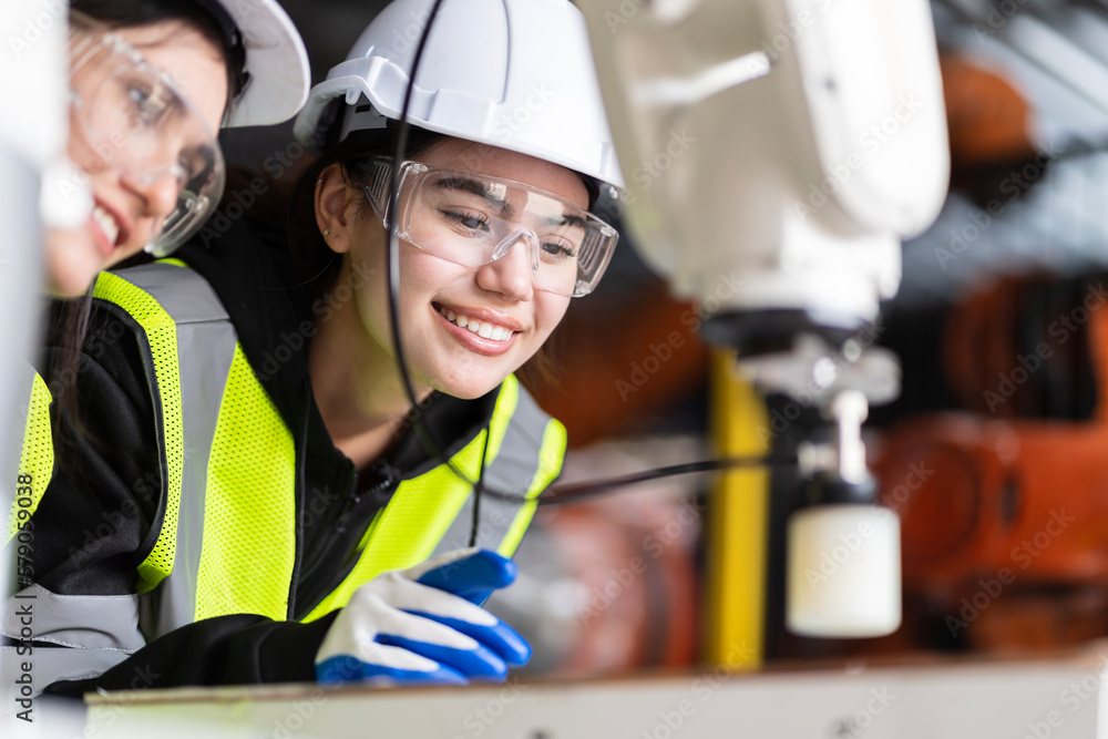 A team of female engineers meeting to inspect computer-controlled steel welding robots. Plan for rehearsals and installation for use. A team of female engineers meeting to inspect computer-controlled steel welding robots. Plan for rehearsals and installation for use.