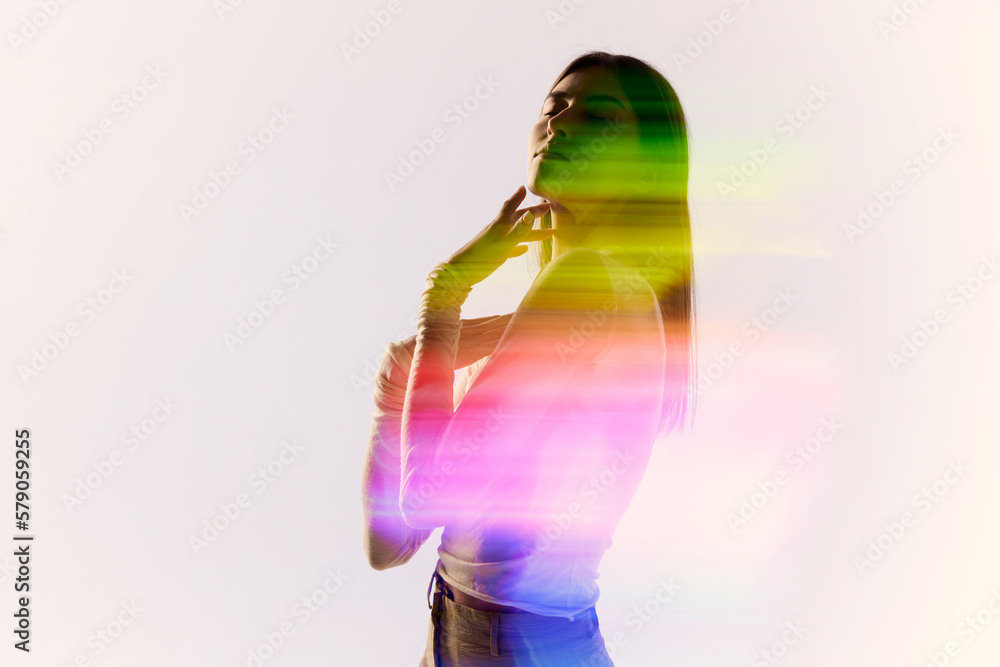 Φωτογραφία Surreal portrait of young adorable woman posing over white background with mixed neon colored light on her body