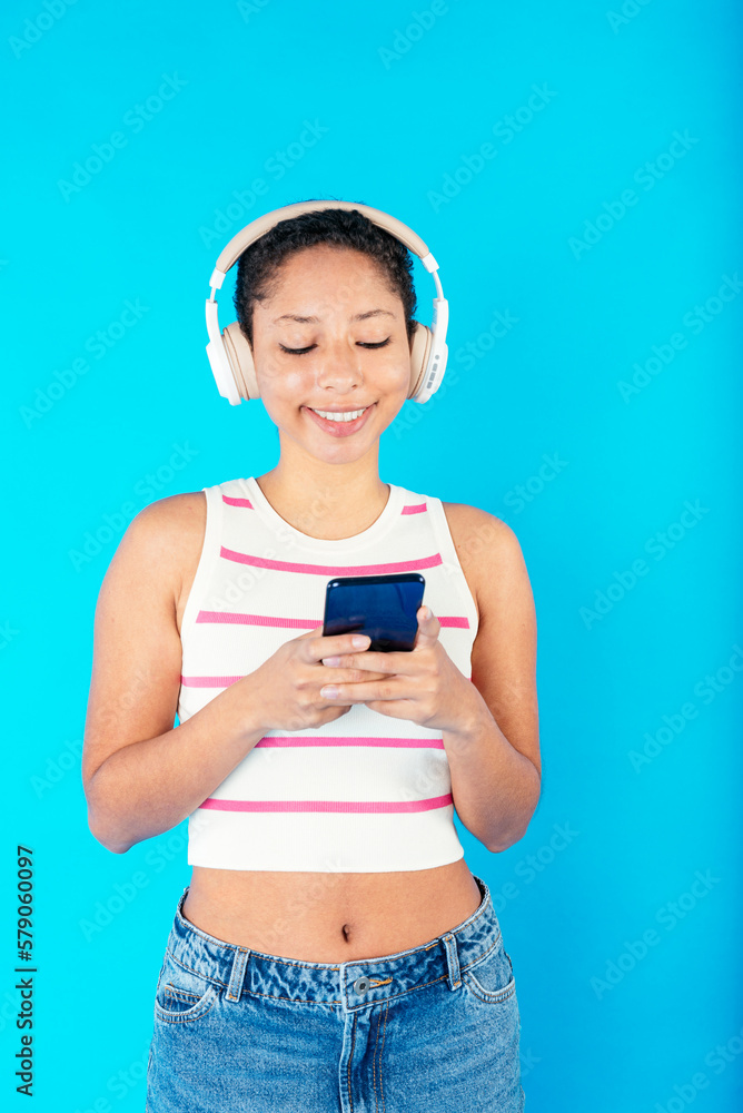 Calm ethnic woman browsing smartphone in headphones Calm ethnic woman browsing smartphone in headphones