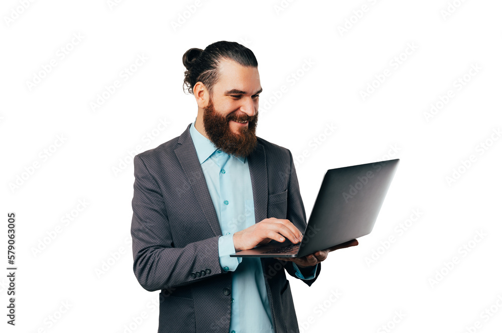 Portrait of a handsome man wearing a jacket and typing on the laptop he holds. Portrait of a handsome man wearing a jacket and typing on the laptop he holds.