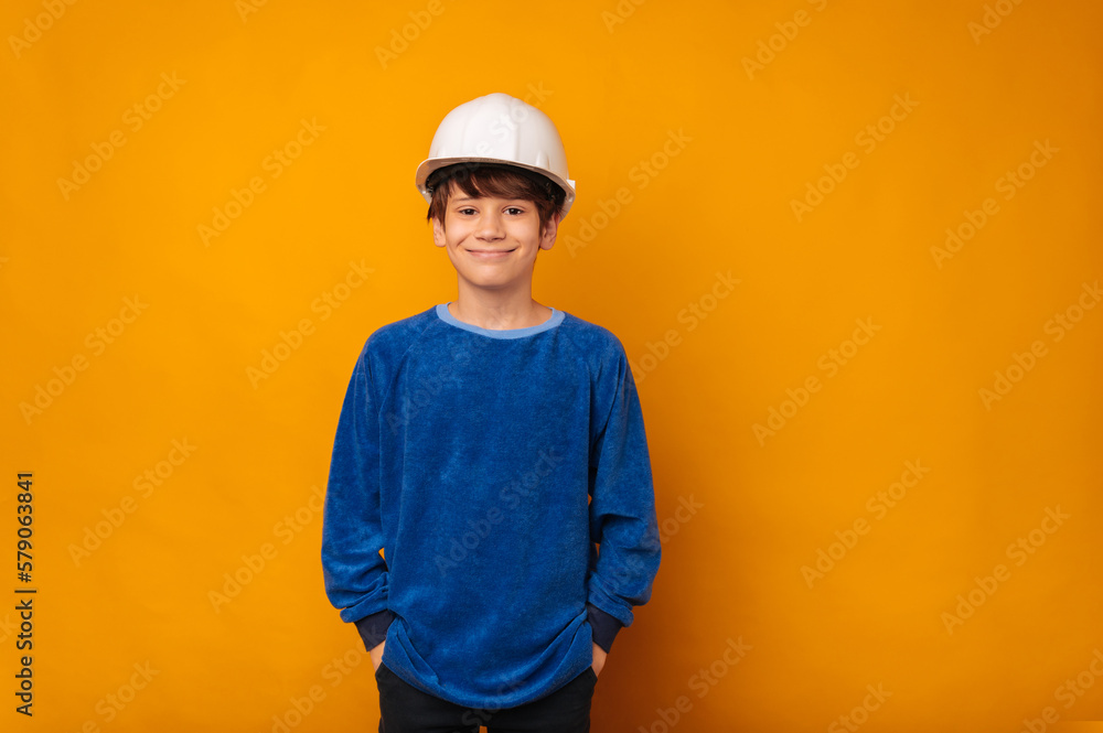 Teen boy wearing a white protection hard hat thinks about being an engineer.