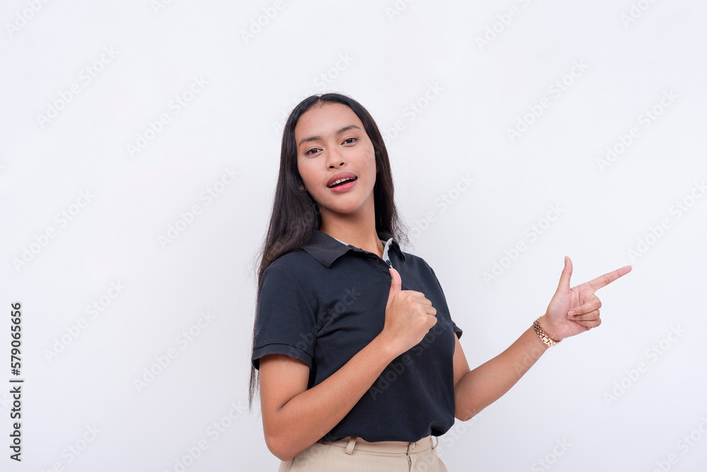 An asian woman confidently points to the right while giving a thumbs up gesture. Isolated on a white background. An asian woman confidently points to the right while giving a thumbs up gesture. Isolated on a white background.