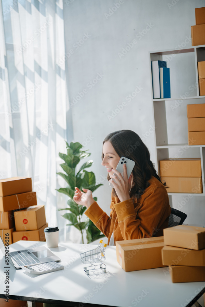 Young business owner woman prepare parcel box and standing check online orders for deliver to customer on tablet, laptop Shopping Online concept.. Young business owner woman prepare parcel box and standing check online orders for deliver to customer on tablet, laptop Shopping Online concept..
