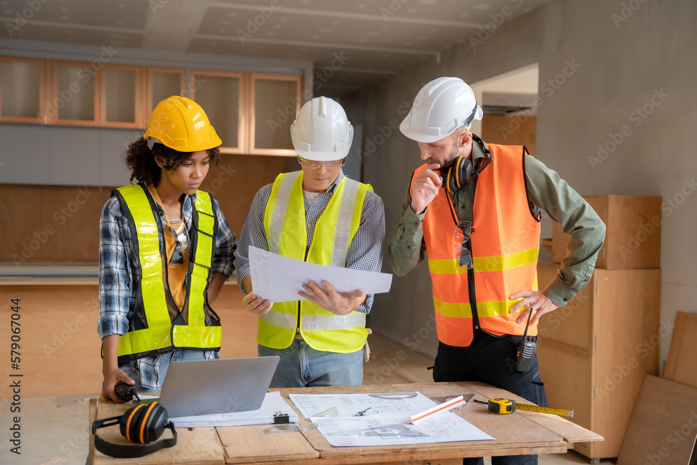 Architect colleagues mixed race working as a team discussing data working and tablet, laptop with on on architectural project at construction site at desk. Architect colleagues mixed race working as a team discussing data working and tablet, laptop with on on architectural project at construction site at desk.