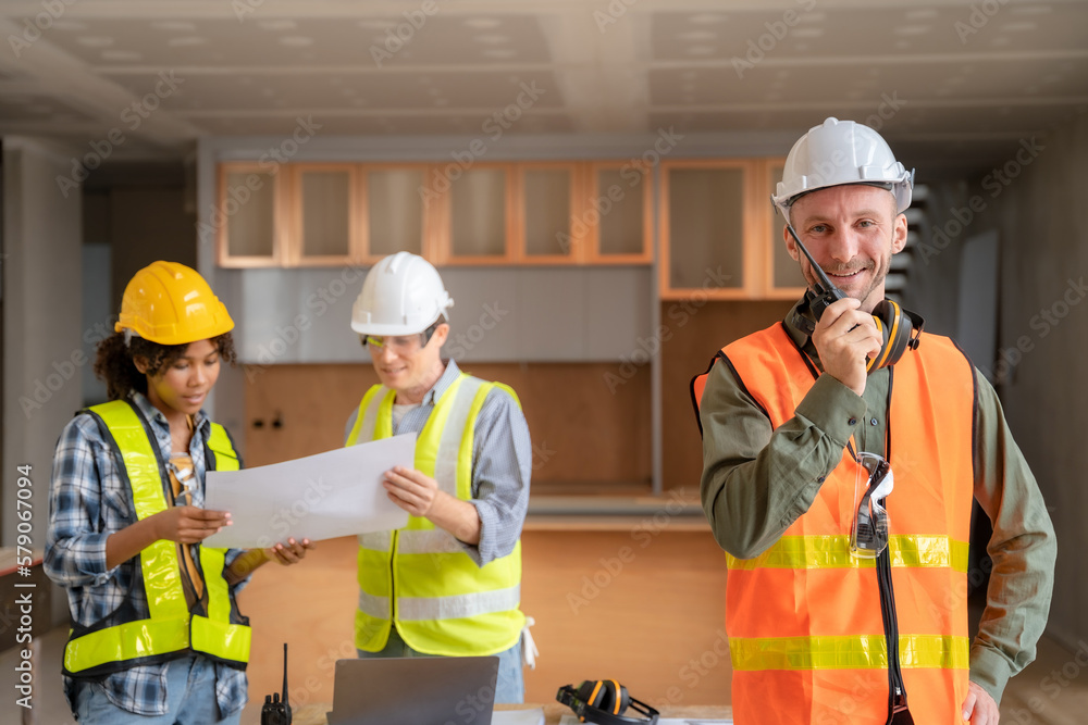 Architect colleagues mixed race working as a team discussing data working and tablet, laptop with on on architectural project at construction site at desk. Architect colleagues mixed race working as a team discussing data working and tablet, laptop with on on architectural project at construction site at desk.