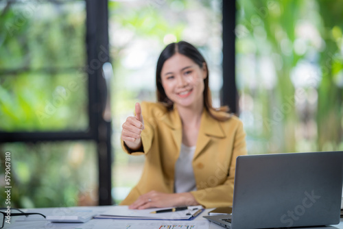 Happy businesswoman talking on mobile phone while analyzing weekly schedule in the office.