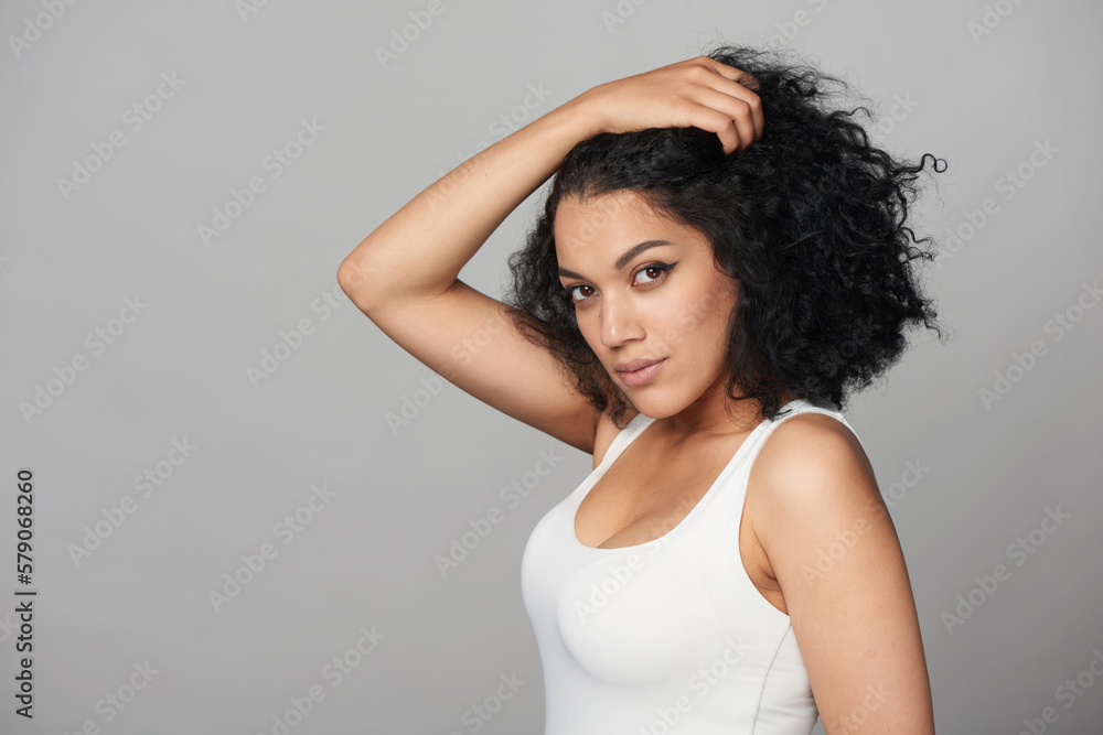 Mixed race african girl with natural curly black hair with hand on head Mixed race african girl with natural curly black hair with hand on head