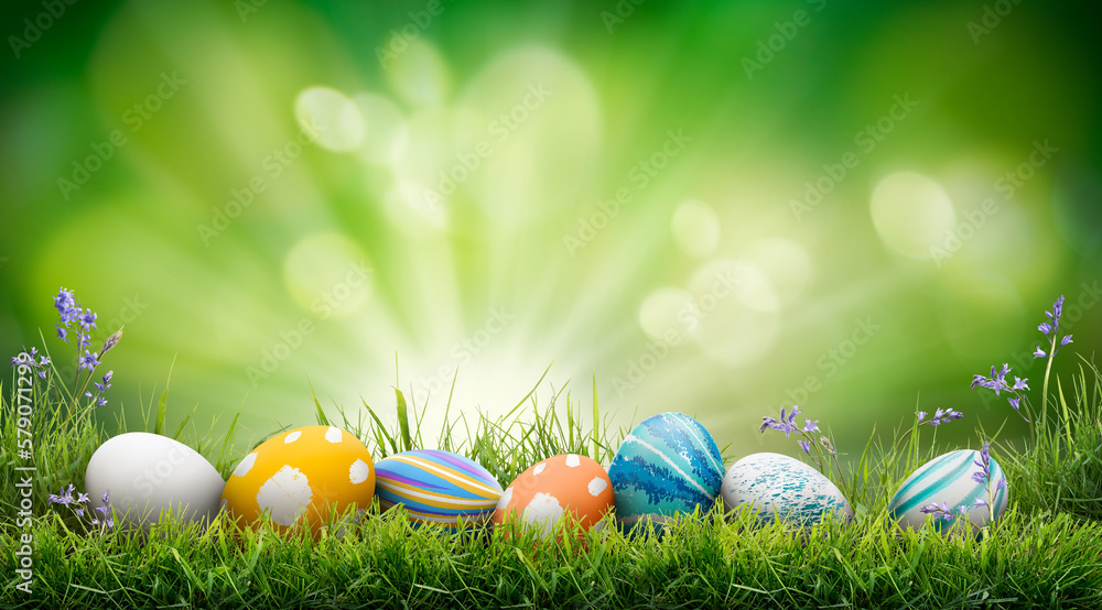 A collection of painted easter eggs celebrating a Happy Easter on a spring day with green grass meadow background with copy space.