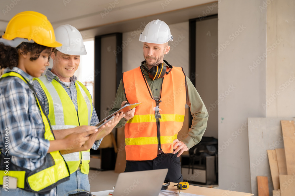 Architect colleagues mixed race working as a team discussing data working and tablet, laptop with on on architectural project. Architect colleagues mixed race working as a team discussing data working and tablet, laptop with on on architectural project.