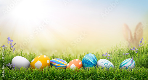 Obraz na płótnie A collection of painted easter eggs celebrating a Happy Easter on a spring day with green grass meadow background with copy space. w salonie
