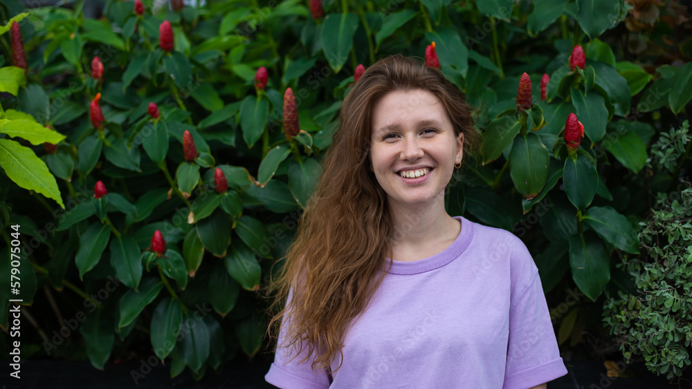 portrait of young girl on a green, natural background, eco friendly woman in a tropical park or jungle, positive lady enjoys walk at summer day portrait of young girl on a green, natural background, eco friendly woman in a tropical park or jungle, positive lady enjoys walk at summer day