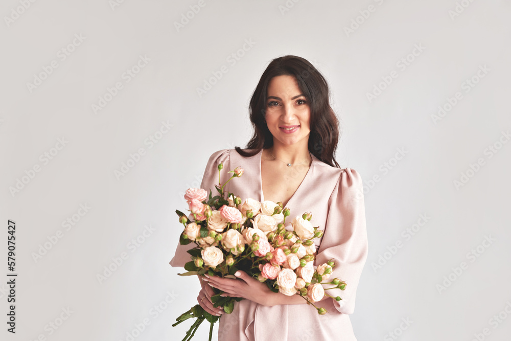 Beautiful young woman with bouquet flowers of roses. International Women's Day. Beautiful young woman with bouquet flowers of roses. International Women's Day.