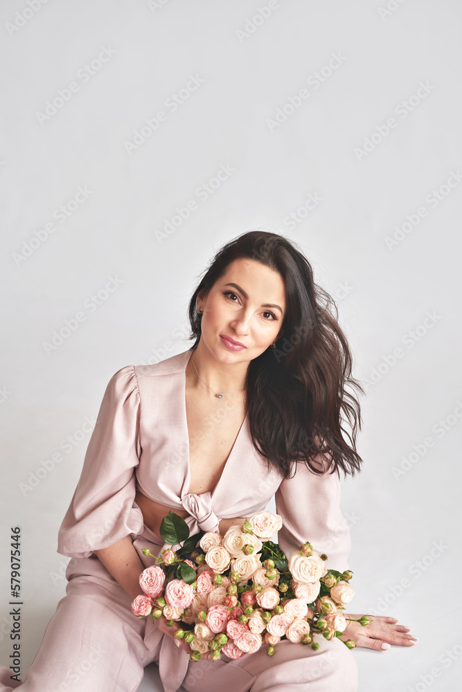Beautiful young woman with bouquet flowers of roses. International Women's Day. Beautiful young woman with bouquet flowers of roses. International Women's Day.