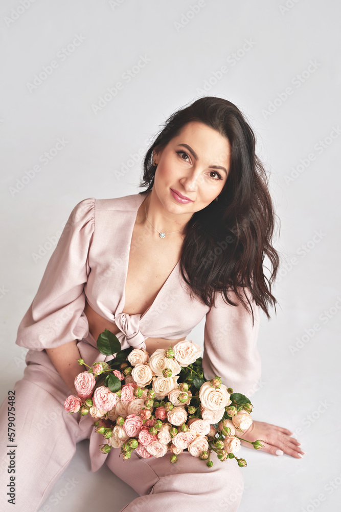 Beautiful young woman with bouquet flowers of roses. International Women's Day. Beautiful young woman with bouquet flowers of roses. International Women's Day.