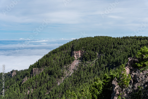 montaña de pinos y formacion rocosa circular con vistas del cielo el mar y un increíble mar de nubes