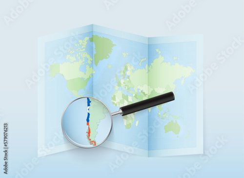 A folded world map with a magnifying lens pointing towards Chile. Map and flag of Italy in loupe.