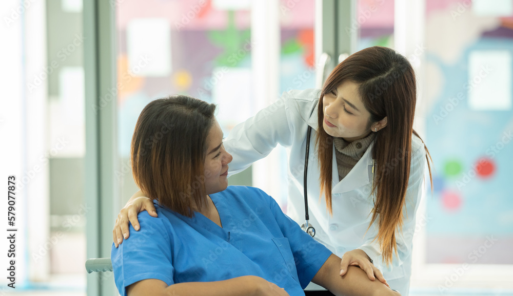 woman obstetrician doctor look holding hand to consoling encourage woman pregnant patient on wheelchair in hospital. woman doctor talk diagnosis treatment for mother pregnancy woman obstetrician doctor look holding hand to consoling encourage woman pregnant patient on wheelchair in hospital. woman doctor talk diagnosis treatment for mother pregnancy