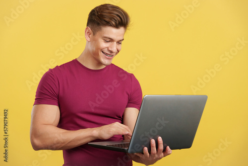 Strong and happy man using a laptop and smiling