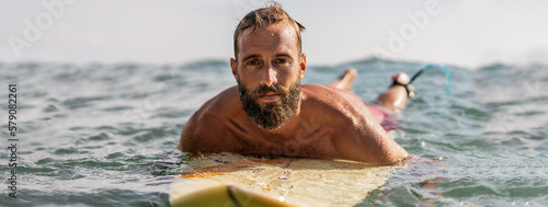 Photography Horizontal banner or header with young hipster man swimming on the surfboard int