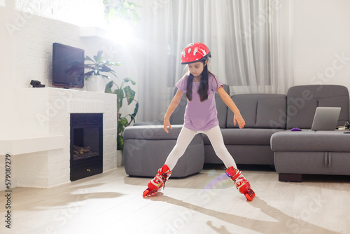 Caucasian little girl in roller skates standing at the living room © Angelov