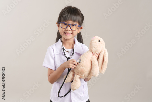Kid doctor holding a stethoscope. Kid role playing doctor.