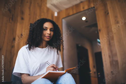 Confident African American woman writing notes