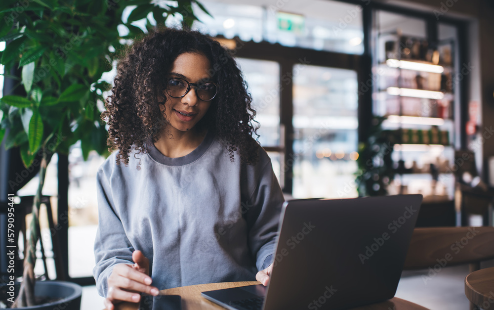 Smiling ethnic woman working with laptop in cafe Smiling ethnic woman working with laptop in cafe
