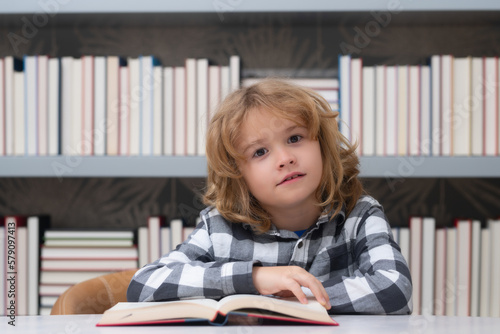 Education and school concept. Child reading a book in a school library. School boy education concept.