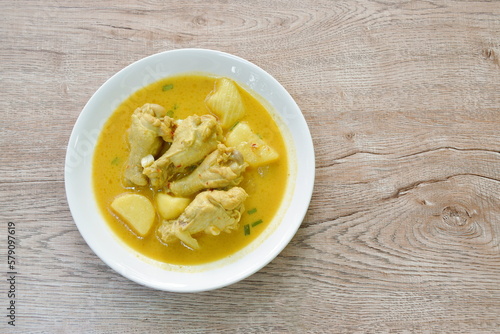 chicken drumsticks massaman curry with slice potato and onion on plate