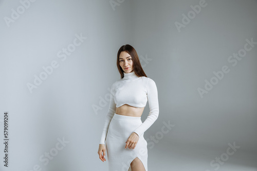 A girl in a white dress on a gray background