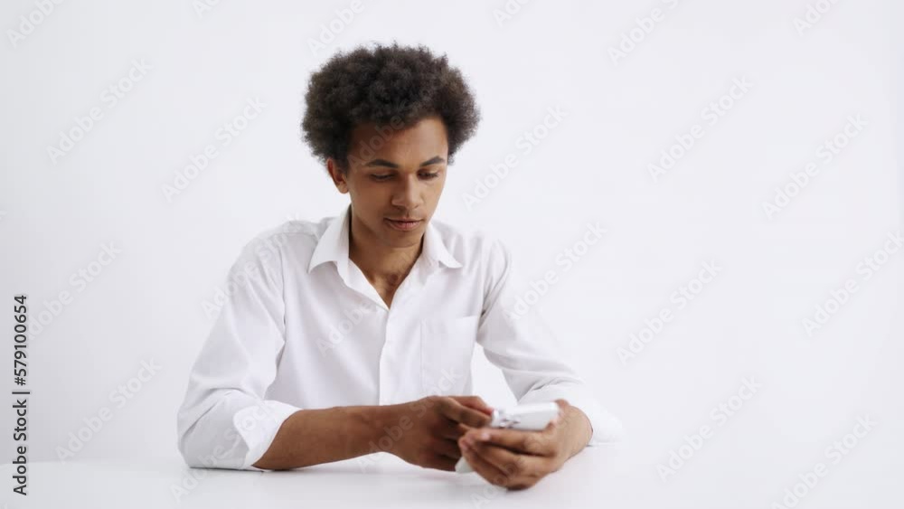 Young multiracial man using phone on white background, futuristic technology Young multiracial man using phone on white background, futuristic technology