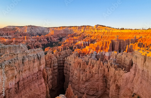 Aerial sunrise view of impressive hoodoo sandstone rock formations in Bryce Canyon National Park, Utah, USA. First morning sun rays touching on natural unique amphitheatre sculpted from red rocks