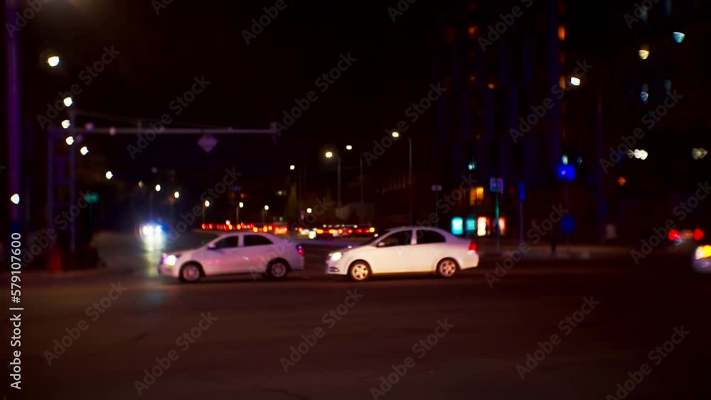cars with headlights on drive at night along a busy city road.blurred defocused video on the theme of city life. cars with headlights on drive at night along a busy city road.blurred defocused video on the theme of city life.