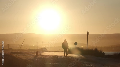 Man walking dog early morning sun Reykjavik Iceland slow motion photo