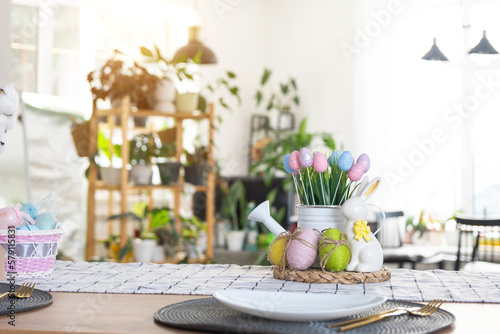 Wallpaper Mural Easter decoration of colorful eggs in a basket and a rabbit on the kitchen table in a rustic style. Festive interior of a country house Torontodigital.ca