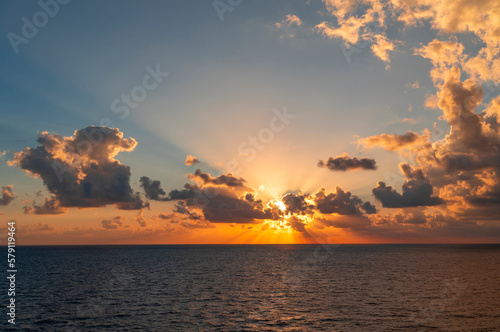 sunrise with light from behind the cloud in the sea