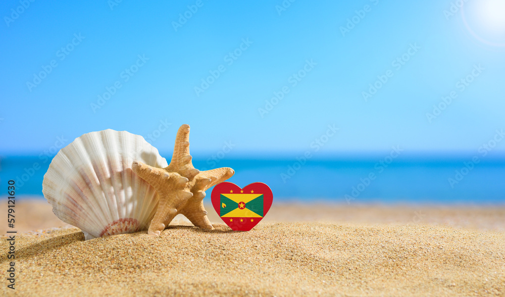 Obraz premium Beautiful beach in the Grenada. Flag of Grenada in the shape of a heart and shells on a sandy beach.