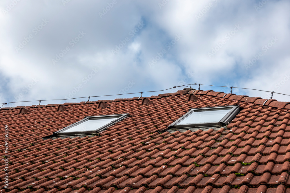 Roof covering with windows under the sky and clouds