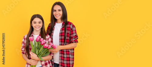 Mother and daughter child banner, copy space, isolated background. glad mother and daughter with tulip flowers on yellow background.