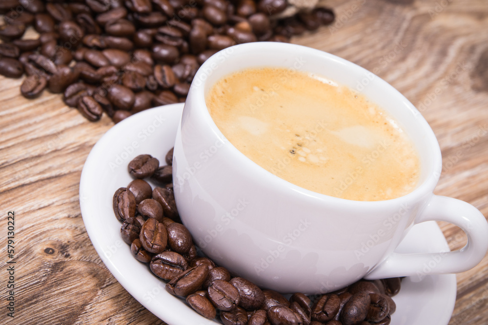 Coffee in cup and roasted dark coffee beans Coffee in cup and roasted dark coffee beans