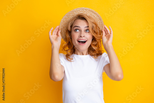 Expressive girl with surprised face. Young redhead woman in straw hat, surprised expression, isolated on yellow background. Summer lifestyle studio portrait.