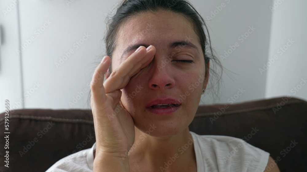 Sad woman taking a deep breath feeling anxious. Crying female person close up face with desperate expression and rubbing eye with hand during hard times Sad woman taking a deep breath feeling anxious. Crying female person close up face with desperate expression and rubbing eye with hand during hard times
