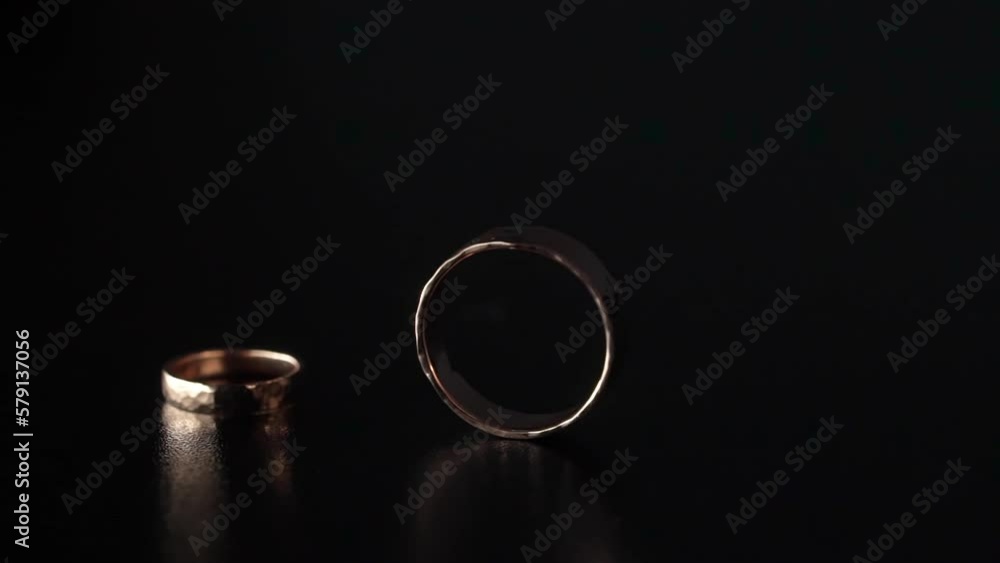 Wedding rings jewelry. Two gold rings on black background. Marriage and proposal engagement ring rolls. Wedding rings jewelry. Two gold rings on black background. Marriage and proposal engagement ring rolls.