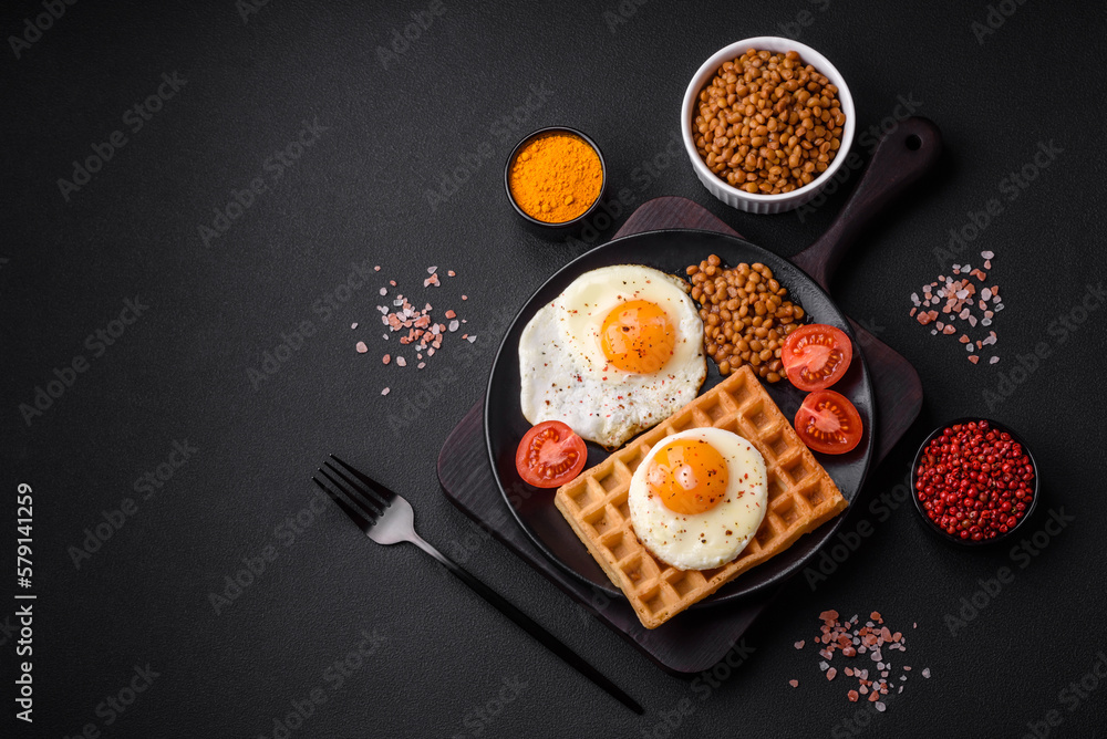 Delicious hearty breakfast consisting of a fried egg, Belgian waffle Delicious hearty breakfast consisting of a fried egg, Belgian waffle