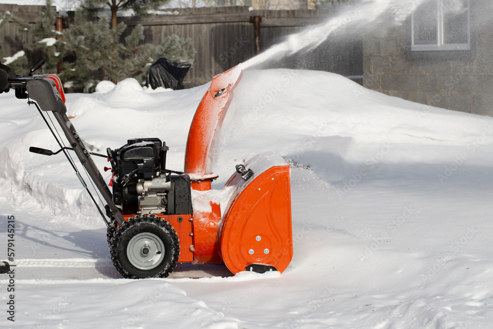 A portable snow blower powered by gasoline. Snow removal in winter. A portable snow blower powered by gasoline. Snow removal in winter.